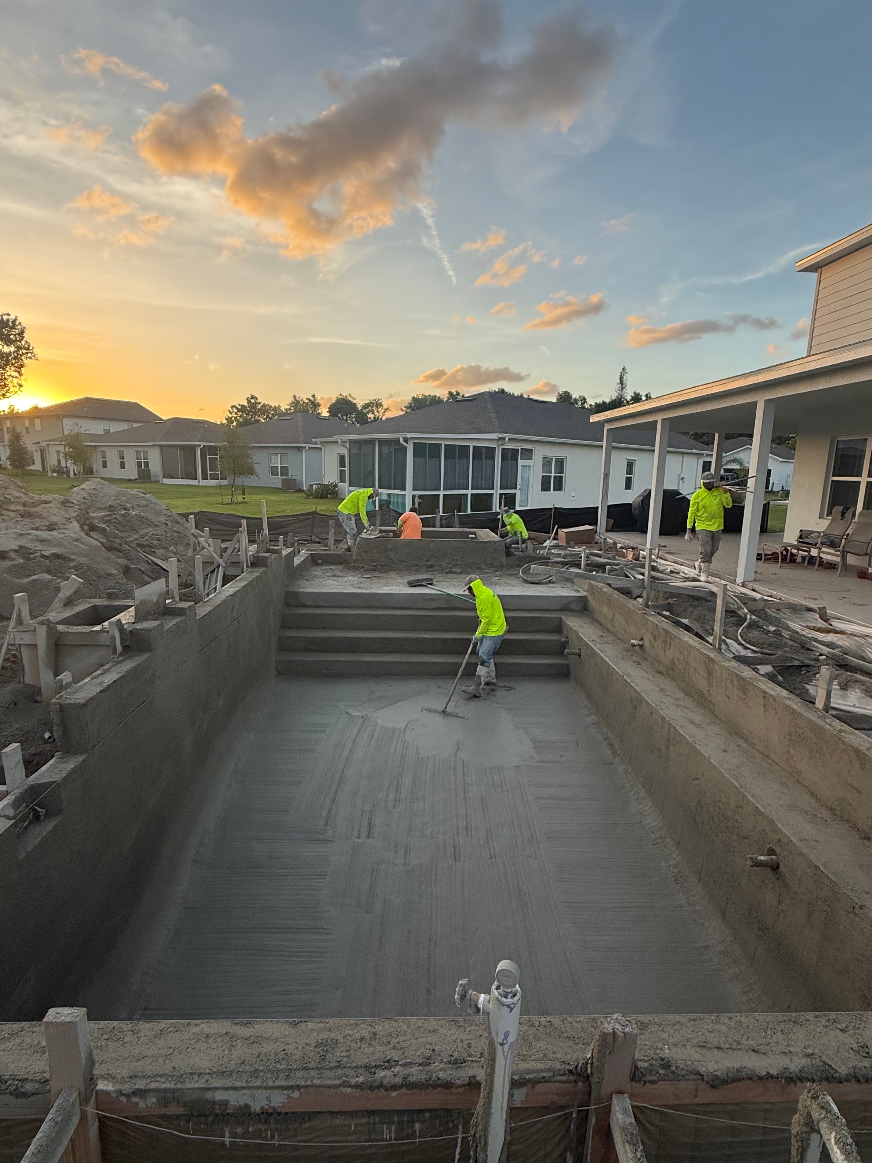 Southern Gunite crew working at sunset on pool project